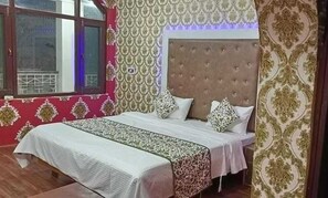 Quarto com cama, papel de parede estampado e janela com vista.