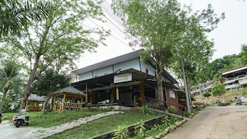 A building with a covered outdoor area, a staircase, and a sign that reads 'GREEN GEN.'