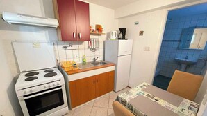 Une cuisine de taille réduite équipée d’une cuisinière, d’un four, d’un évier et d’un réfrigérateur.