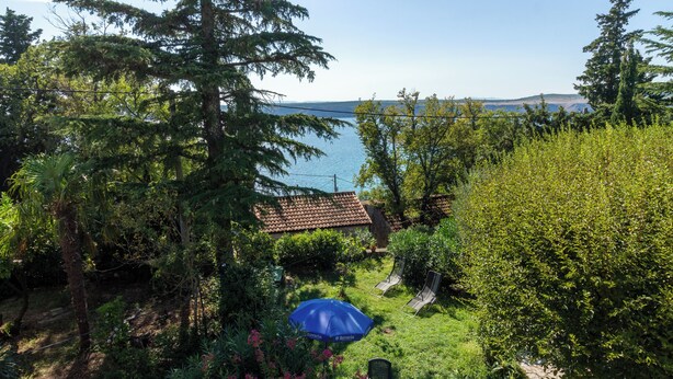 A garden with a view of the sea, a blue umbrella, and a chair. - Apartment Azzuro Bay 2 (Jadranovo)