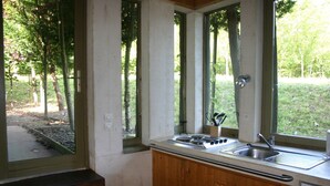 Une cuisine équipée d’une cuisinière à gaz, d’un évier et de meubles de rangement en bois.