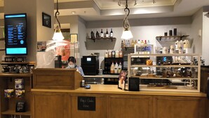 Mostrador de cafetería con un cartel que indica pago y pedidos.