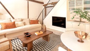 Una sala de estar moderna con sofá, mesa de centro y televisor.