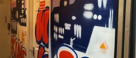 A hallway with doors featuring graffiti-style artwork and a 'No entry' sign.