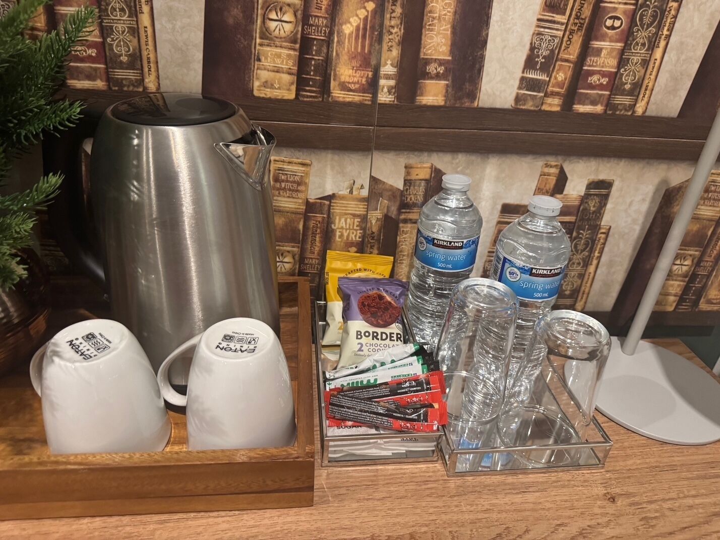 Un coin café équipé d’une bouilloire, de tasses et d’un plateau contenant des en-cas et des bouteilles d’eau.