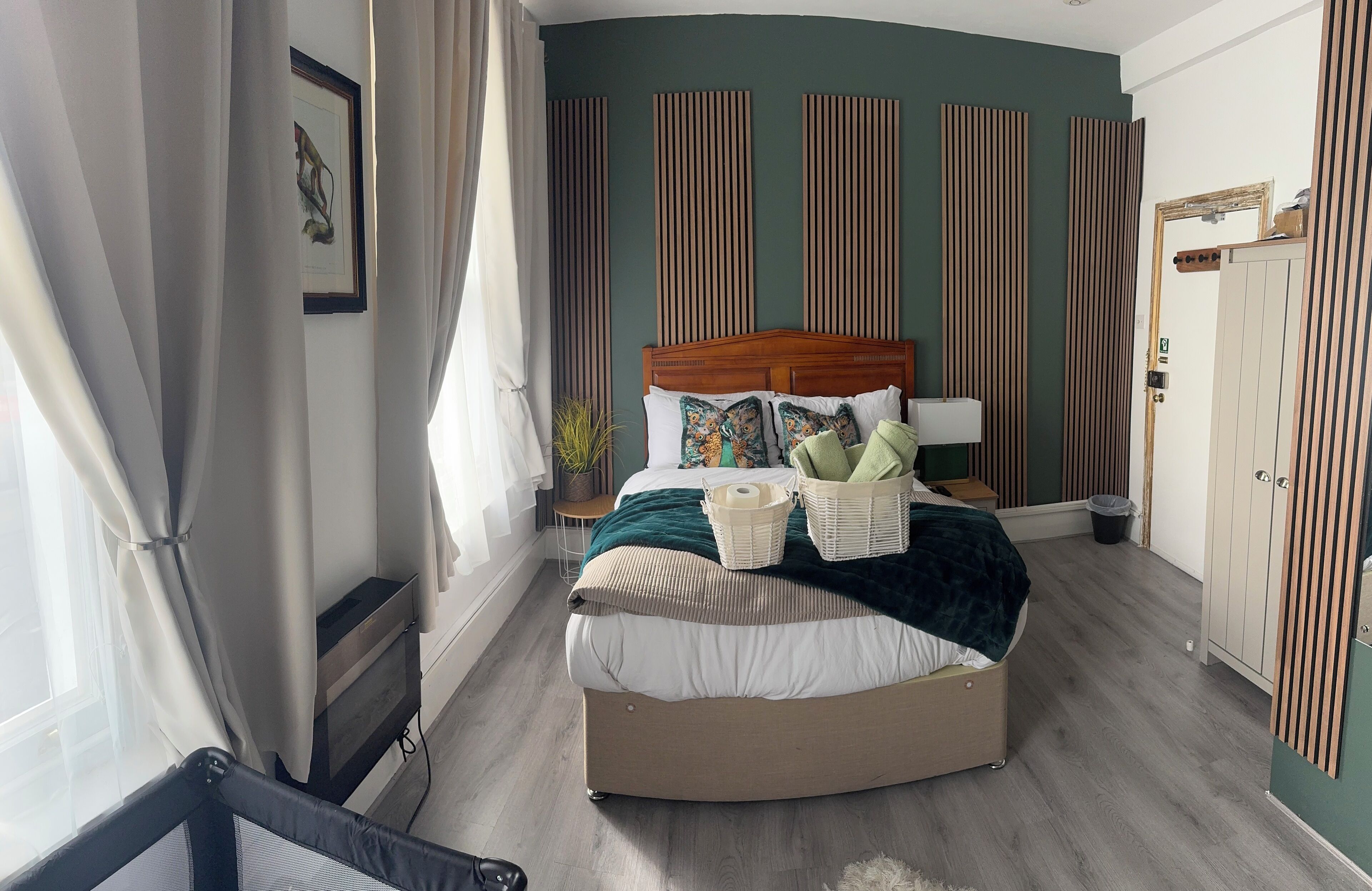 A bedroom with a curved bed, a bedside table, a lamp, a dresser, and a wardrobe.