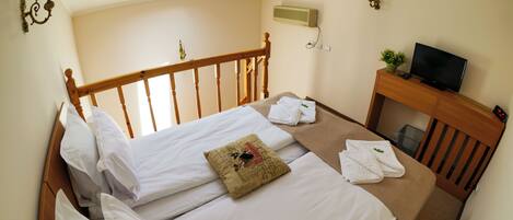 A hotel room with a bed, a TV, and a small desk.