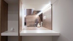 A modern kitchen with a wooden countertop, a hanging rack, and a small island. - Arco Miraglia suite - Apulia Houses & Flats (Ruvo di Puglia)