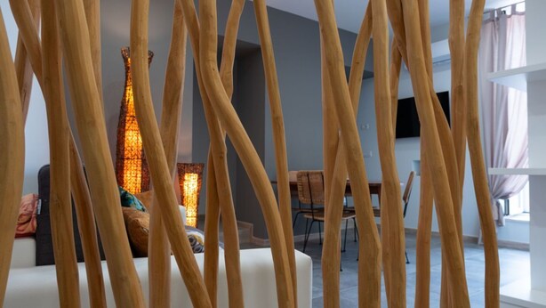 A modern living room with a sofa, a dining table, and a decorative light fixture. - Arco Miraglia suite - Apulia Houses & Flats (Ruvo di Puglia)
