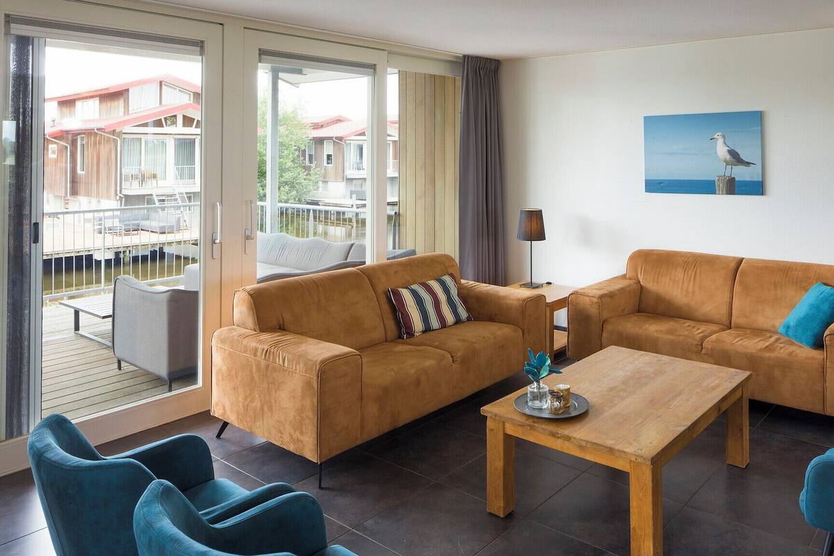 A modern living room with two sofas, a coffee table, and blue chairs.