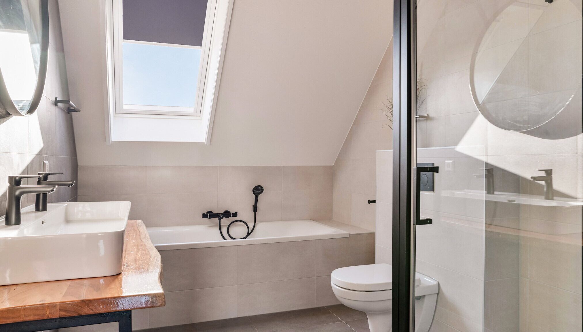 A modern bathroom with a freestanding bathtub, a toilet, and a large mirror.