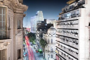 Une rue de la ville bordée de bâtiments historiques, dont un bâtiment doté d’un dôme et de balcons.