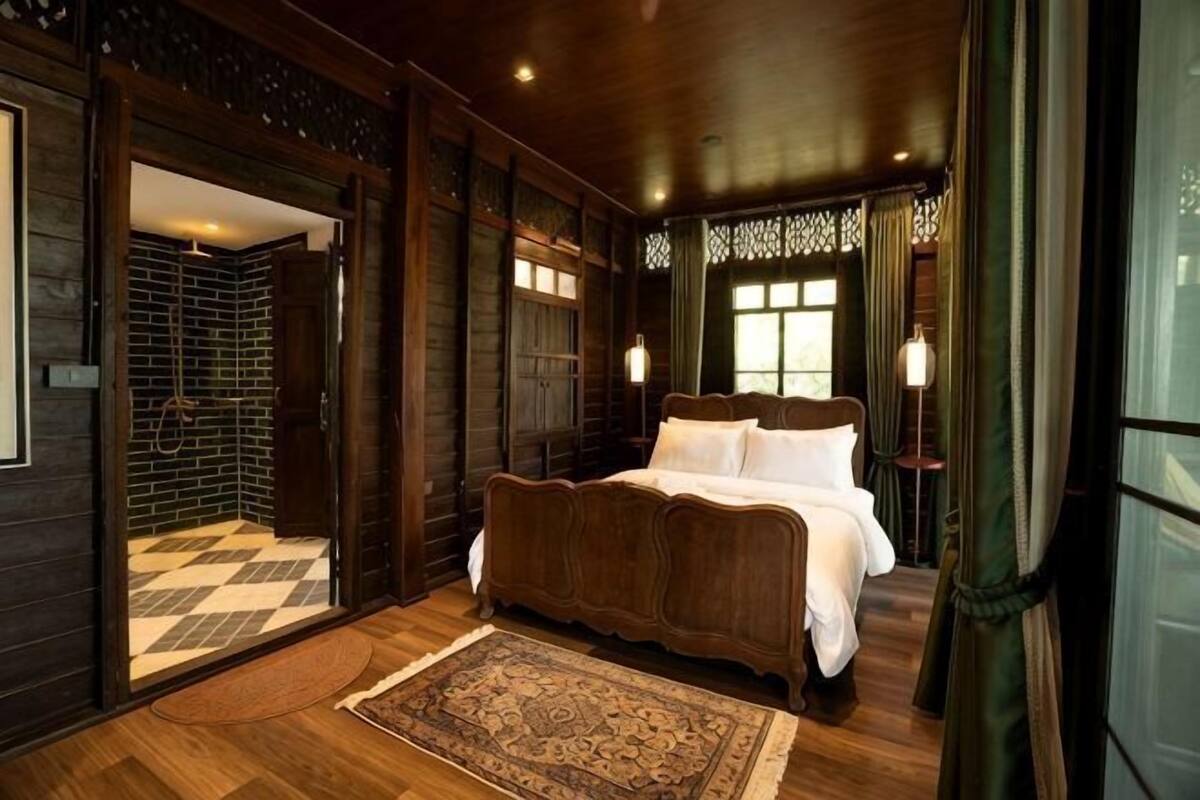 A bedroom with a large bed, wooden walls, and a checkered floor.