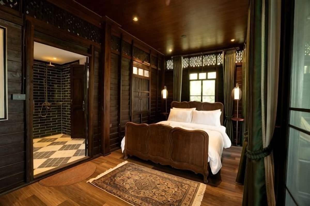 Une chambre Ă coucher avec un grand lit, des murs en bois et un sol Ă carreaux.