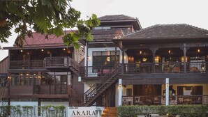 A multi-story building with a sign reading "AKARA HOUSE SUKHOTHAI". - Akara House Sukhothai (Si Satchanalai)