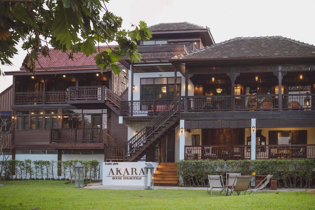 A multi-story building with a sign reading "AKARA HOUSE SUKHOTHAI".