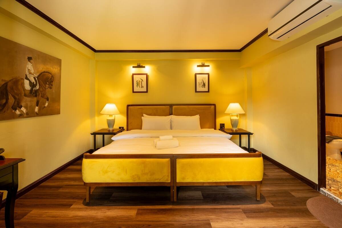 A large bed with two bedside tables, a headboard, and two wall-mounted lamps.