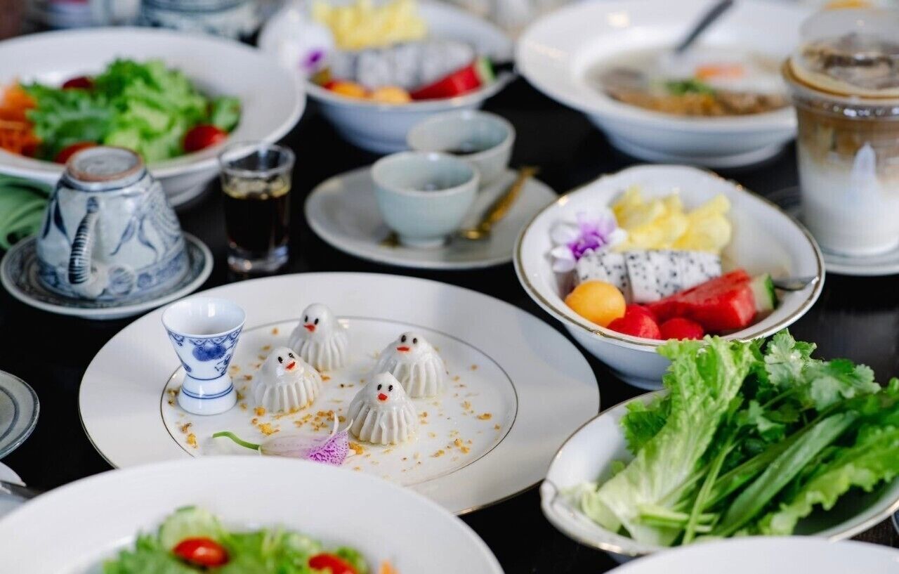 A table set with various dishes, including a salad, fruit, and decorative items.