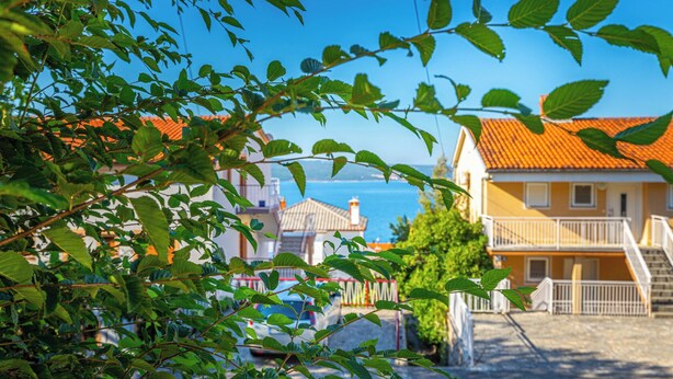 A coastal building with a red-tiled roof, a staircase, and a view of the sea. - Apartman Franjo 1 (Dramalj)