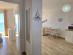 Welcome to a bright and airy living space with a dining area for four, sofa, and balcony with a view.