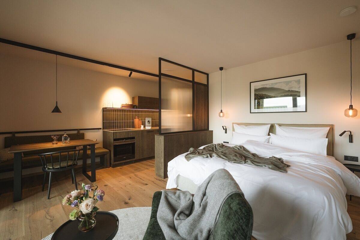 Una habitación de hotel moderna con una cama, un escritorio y una zona de estar.