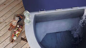 Relax in the hot tub, surrounded by a deck with a selection of refreshments.