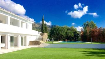 Situated in a lush landscape, this two-story building offers a serene escape with a well-maintained lawn and steps leading to the entrance.
