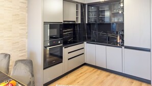 Een moderne keuken met een inbouwoven, magnetron en een glazen kast.