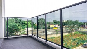Un balcón con vista a una autopista y follaje circundante.