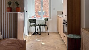 A compact kitchen with a dining area, a sofa, and a small table. - Home Chic Home – Le Cocon de Paris La Défense (La Garenne-Colombes)
