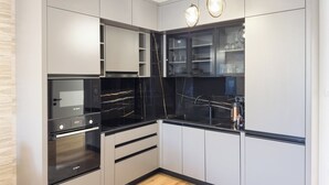 A modern kitchen with grey cabinets, a black countertop, and a Bosch oven. - 2BR Apartment | Free Parking | Central (Plovdiv)