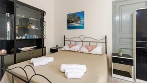 A neatly arranged bedroom with a bed, bedside tables, a wardrobe, and a painting on the wall. - Appartamento Golden Beach Porto Cesareo (Porto Cesareo)
