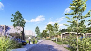 Zona residencial con casas modernas, un camino de entrada pavimentado y una persona caminando.