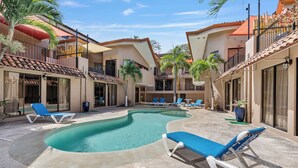 A pool area with lounge chairs and a curved pool. - Dual Kitchens, Pool, 3-min walk to the Beach (Playa Ocotal)