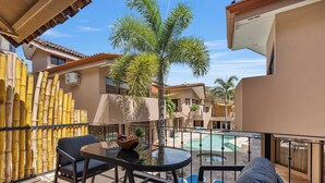 A balcony with a table and chairs, a pool, and a bamboo fence. - Dual Kitchens, Pool, 3-min walk to the Beach (Playa Ocotal)