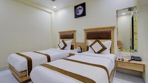 Quarto de hotel com duas camas, uma mesa de cabeceira, um espelho e uma imagem da lua na parede.