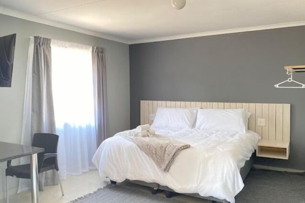 Habitación Confort | Escritorio, espacio para trabajar con laptop y cortinas blackout