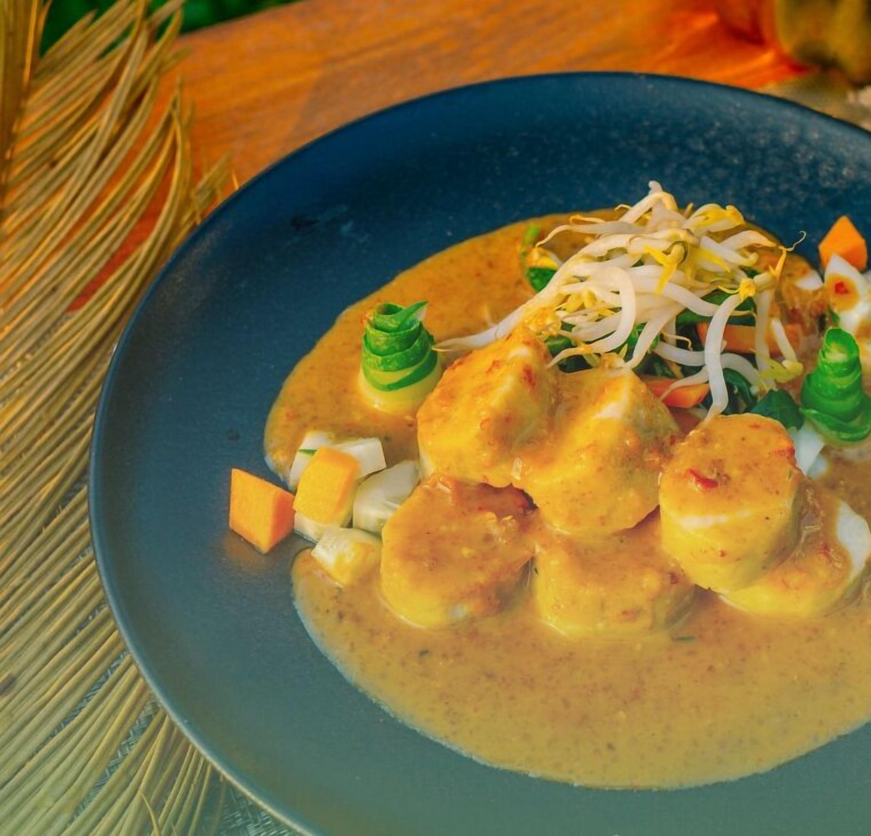 Un plat composé de légumes, de pousses de haricots et d’une sauce crémeuse.