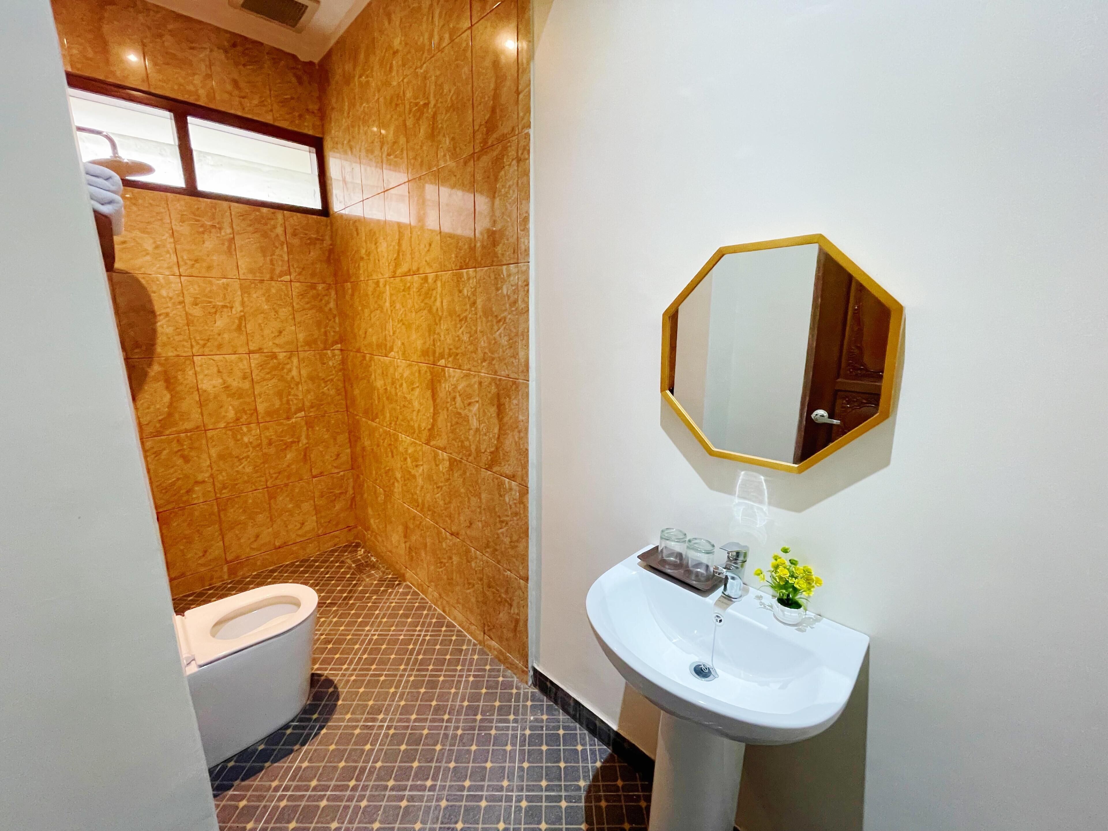 Une salle de bain avec des toilettes, un lavabo et un miroir.
