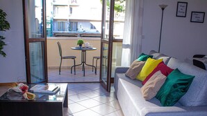 A living room with a sofa, a coffee table, and a dining table with chairs. - CASA IL FIORE (Florence)