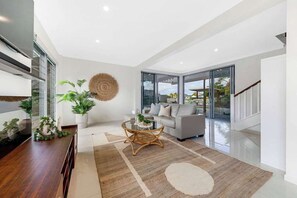 Una sala de estar moderna con un sofá, una mesa de centro y plantas en macetas.