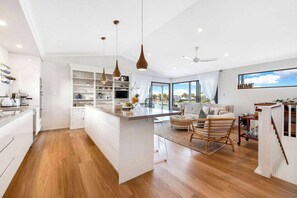 A modern kitchen with white cabinetry, pendant lighting, and a central island.