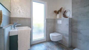 A modern bathroom with a shower, toilet, and sink. - Feinheit Hotel & Restaurant (Halsenbach)
