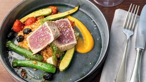A plate of food with various vegetables and a piece of meat, accompanied by a glass of wine and cutlery on a table. - Feinheit Hotel & Restaurant (Halsenbach)