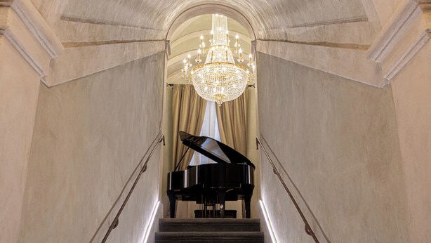 A grand piano on a staircase leading to a room with a chandelier. - Stay in a prestigious place of interest in Florence in the city center (Firenze)