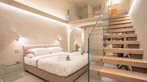 A modern bedroom with a glass-enclosed staircase, a bed with white linens, and a glass bedside table. - Stay in a prestigious place of interest in Florence in the city center (Firenze)