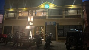 A two-story building with a sign that reads "Fonasa" on the ground floor. There are motorcycles parked in front of the building. - Hostal Don Guillermo (Natales)