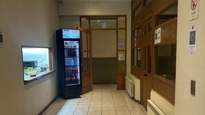 A hallway with a vending machine, a sign reading "Comedor", and a window with a view. - Hostal Don Guillermo (Natales)