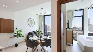 Habitació d'hotel moderna amb zona de dinar, un llit i vista a la ciutat.