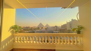 A balcony with a view of the pyramids, wooden flooring, and potted plants. - Roone Pyramids View Inn (Giza)